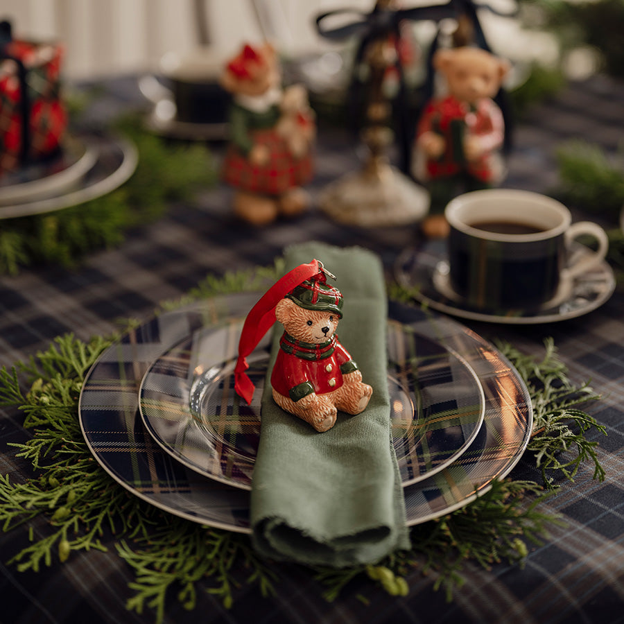 Blårutete dekketallerken på festdekket julebord med grønn serviett, julepynt og kaffekopp