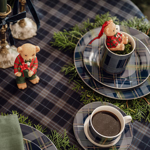 Blårutete dekketallerken med kopp, kaffe og julepynt på dekorert festbord