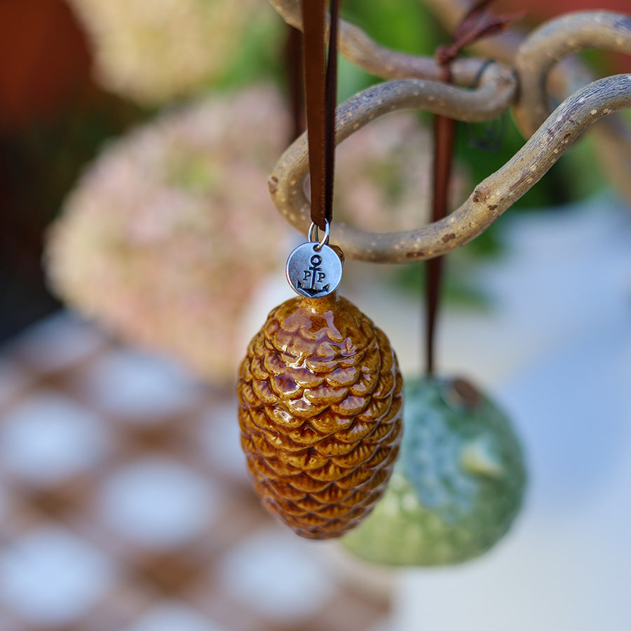 Detaljbilde av brunt keramikkongle ornament med glasert, naturtro overflate