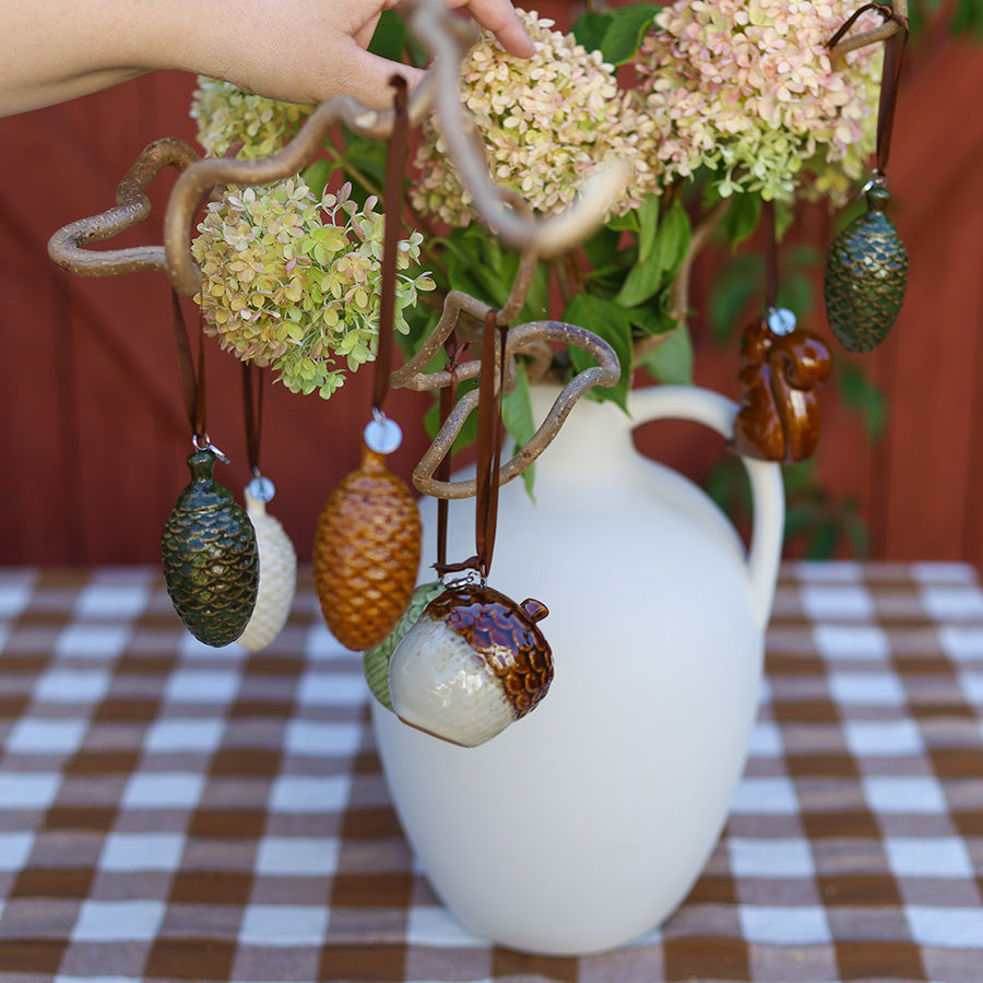 Keramikkongle ornament fra Porsgrunds Porselænsfabrik hengt på dekorativ gren med blomster