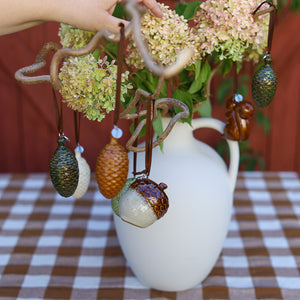 Keramikkongle ornament fra Porsgrunds Porselænsfabrik hengt på dekorativ gren med blomster