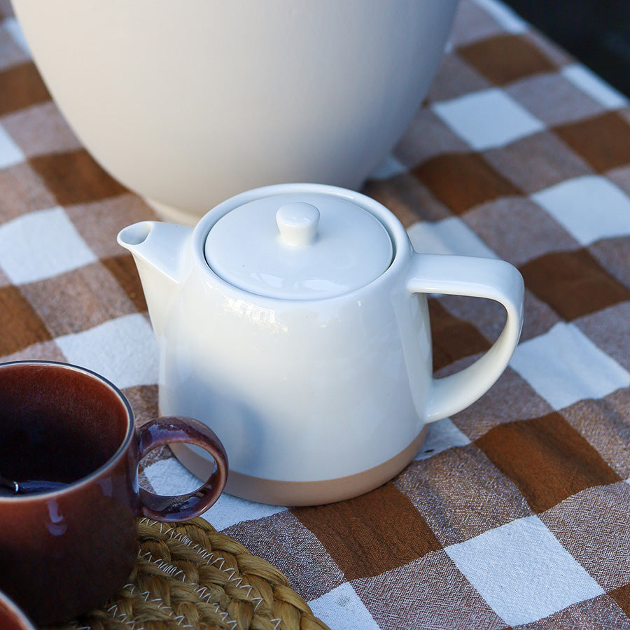 Hvit Porsgrunds Teatime tekanne med lokk på rutete duk, klar for servering