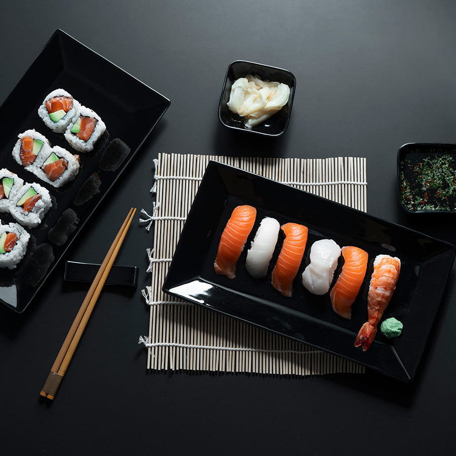 Ett vakkert oppdekket sushi sett med assortert sushi og tilbehør, perfekt for en koselig kveld.
