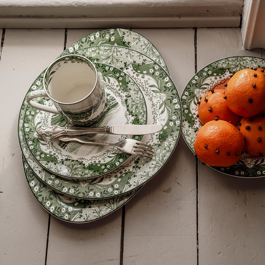 Grønt Porsgrunds Vintage krus med matchende tallerkener, bestikk og dekorative appelsiner