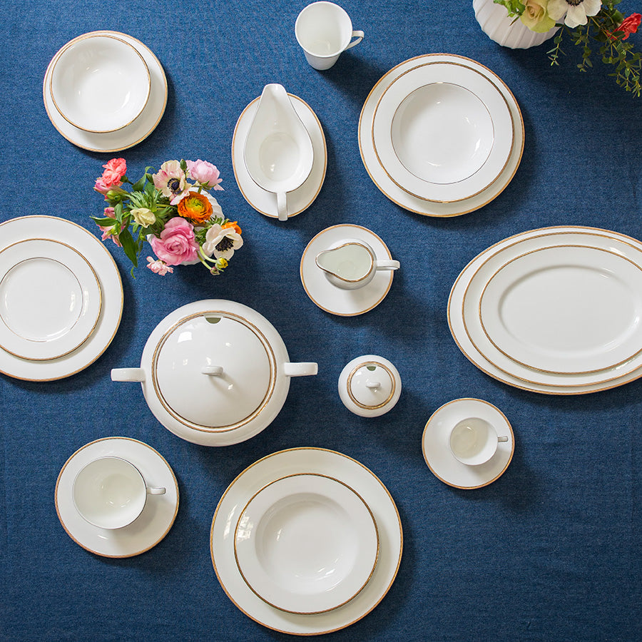 Porsgrunds Porselænsfabrik Nathalie Gull servise sett, inkludert terrin og tallerkener med gullkant, ideelt for festservering og høytider.