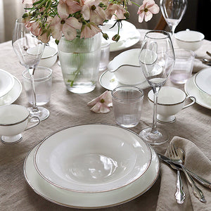 Porsgrunds Porselænsfabrik Nathalie Platinum dekket bord med tekopper, skåler og blomster, perfekt for et elegant middagsselskap.