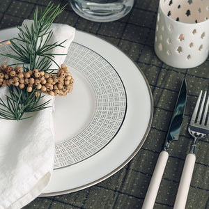 Porsgrund Porselænsfabrik Vivienne Gull Tallerken 22cm dekorerer et elegant bord med serviet og bestikk, perfekt for festlige anledninger.