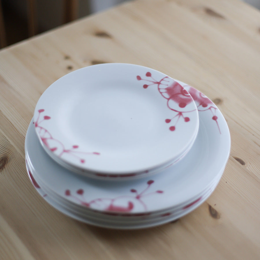 Porsgrund Porselænsfabrik Maxistrå Tallerken 22 cm Rosa, tallerkener stablet på et trebord, fremhever det delikate rosastrå-mønsteret.