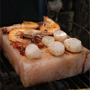 Grillings med Rivsalt Himalaya saltblokk, reker og kamskjell som tilberedes på saltblokken.