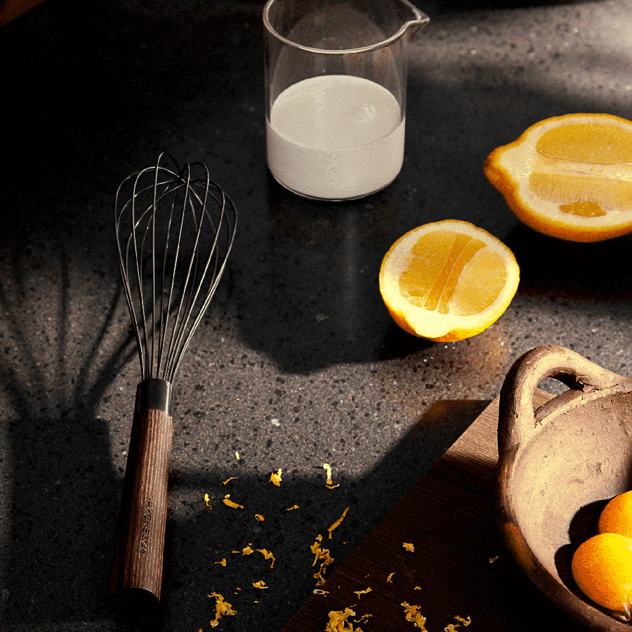 Rosendahl visp plassert på et bord med ingredienser som sitronskiver og melk.