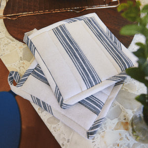 ROSENDAHL Rosendahl Grytekluter 22x22cm 2pk Blå – grytekluter med varmebeskyttende polstring og blå striper, vist på kjøkkenbord