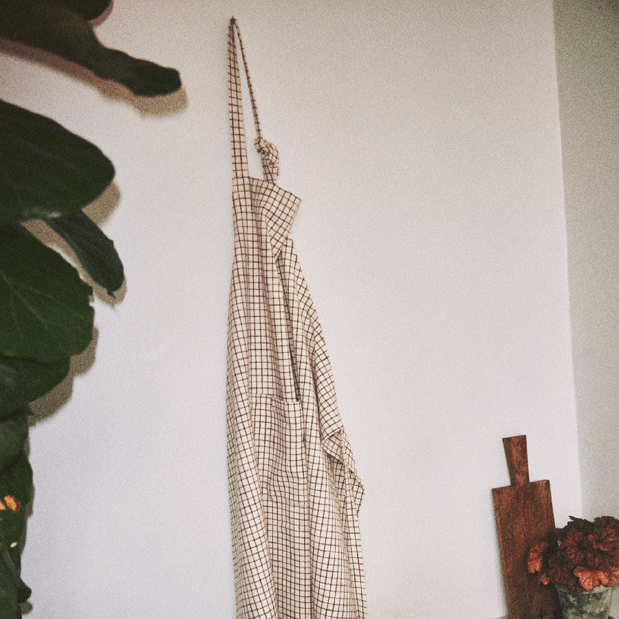 Rosendahl Forkle i terracotta, hengende på veggen, viser sitt stilige og funksjonelle design med justerbare stropper.