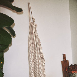 Rosendahl Forkle i terracotta, hengende på veggen, viser sitt stilige og funksjonelle design med justerbare stropper.