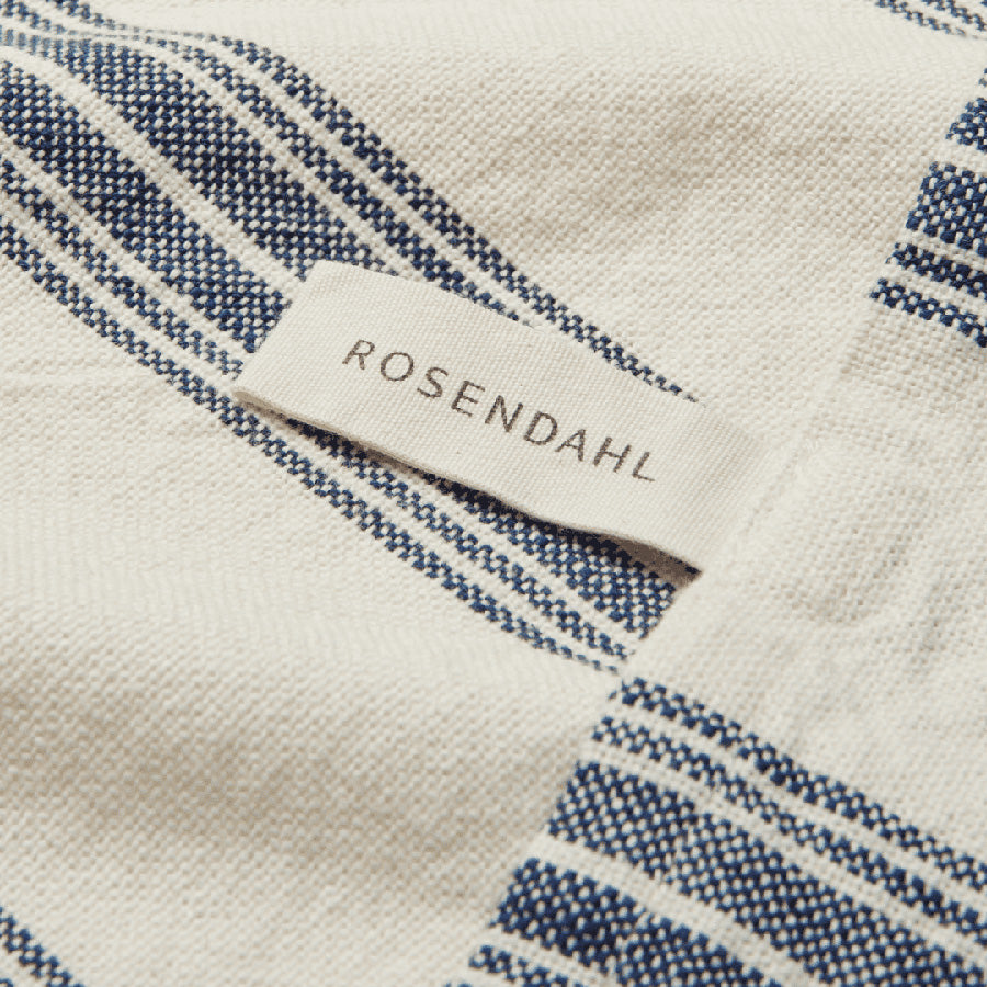 Nærbilde av Rosendahl logo på et kjøkkenhåndkle med blå striper, som viser kvalitet og merkedesign.