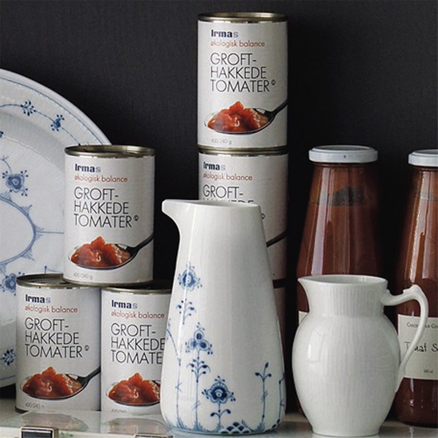 Royal Copenhagen Hvit Riflet Mugge 0,38L plassert sammen med matvarer, som gir et stilrent inntrykk. Ideell til servering av sauser og dressinger.