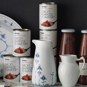 Royal Copenhagen Hvit Riflet Mugge 0,38L plassert sammen med matvarer, som gir et stilrent inntrykk. Ideell til servering av sauser og dressinger.