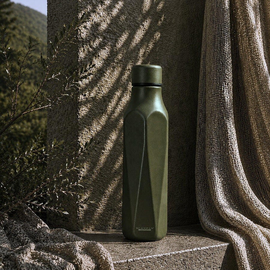 SCANPAN termoflaske 500ml i dyp Pine-grønn farge, plassert på en teksturert overflate i naturlige omgivelser, med fokus på det stilige designet.