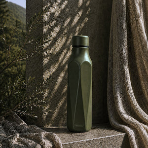 SCANPAN termoflaske 500ml i dyp Pine-grønn farge, plassert på en teksturert overflate i naturlige omgivelser, med fokus på det stilige designet.