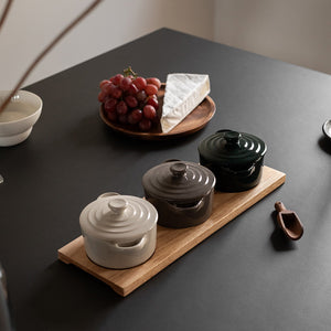Tre stilige serveringsskåler i keramikk på et eikebrett, perfekt for servering av tapas og dips.
