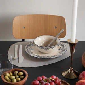 Elegant smaragdgrønn skål fra Seasons Fall Collection, dekket med blå blomsterprint, plassert på et bord med bestikk og moderne stoler.