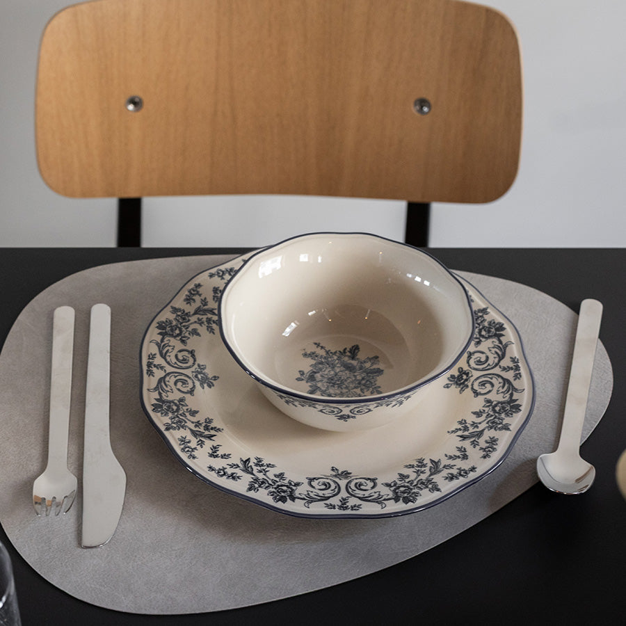 Nærbilde av Seasons Fall Collection skål med blå blomsterprint, plassert på et dekorerte bord sammen med tallerken og bestikk.