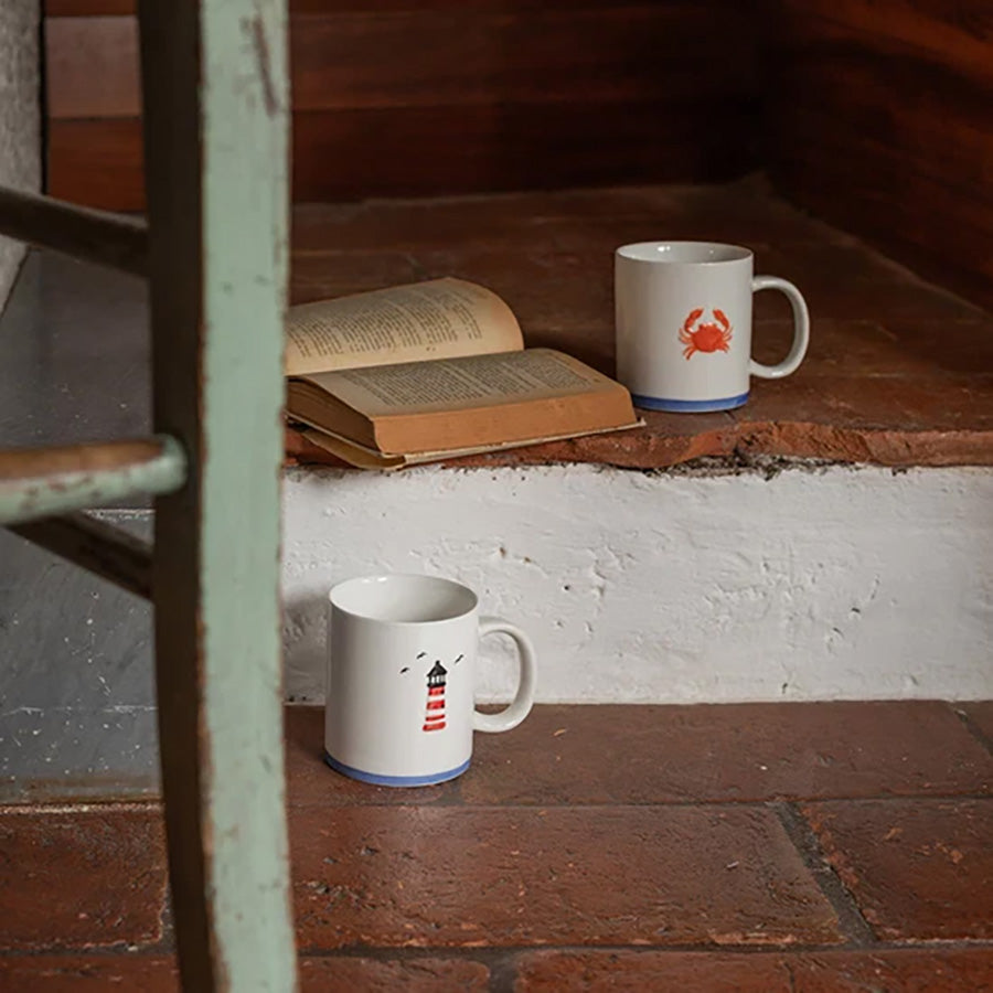 To krus med maritime motiver plassert på trappen, ideelle for en koselig kaffepause.