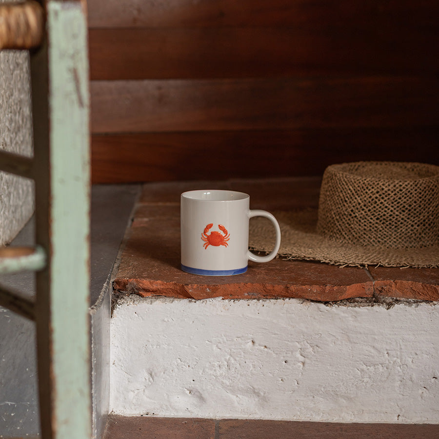 Maritimt krus med rød krabbe motiv, perfekt for sommerlige stunder. Tidløst design med blå kant som passer til kystliv. Ideal for kaffe eller te.