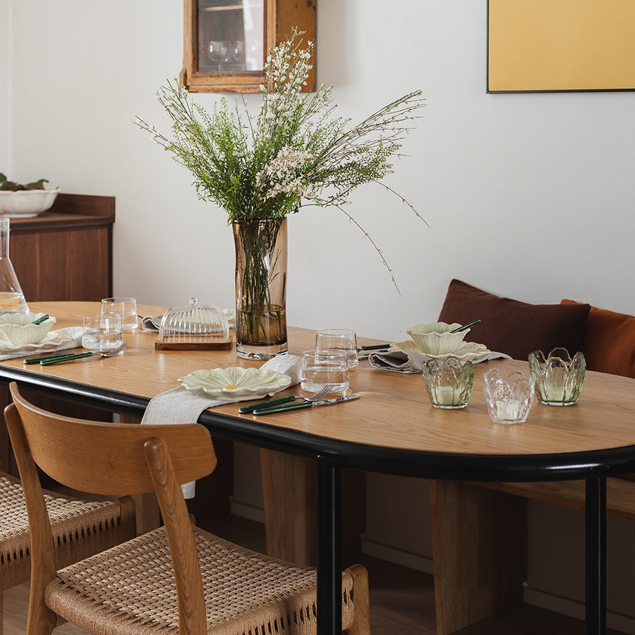 Elegant bordoppsett med Seasons lyslykter i klar glass, 8,5x8 cm, sammen med blomster og dekorerte tallerkener.