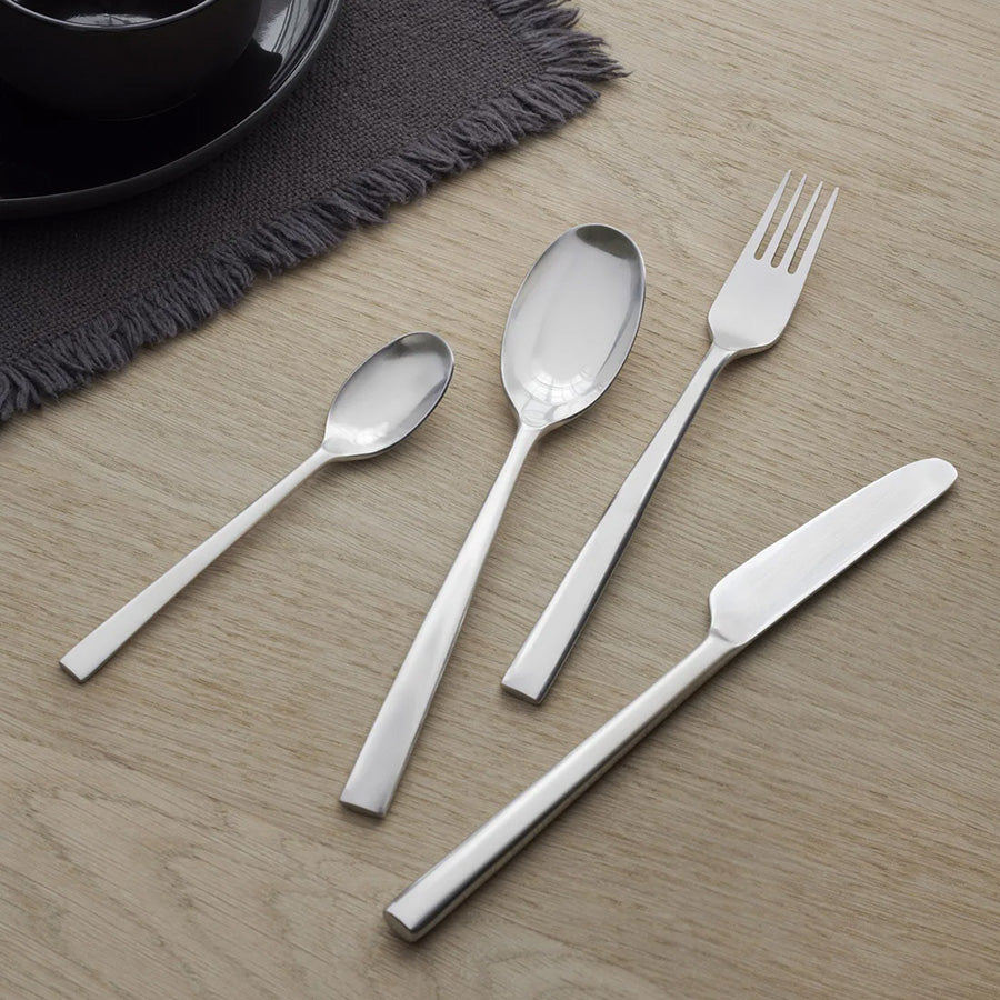 Elegant sett med spisegaffel, spisekniv, spiseskje og teskje i polert rustfritt stål, perfekt for enhver middag.