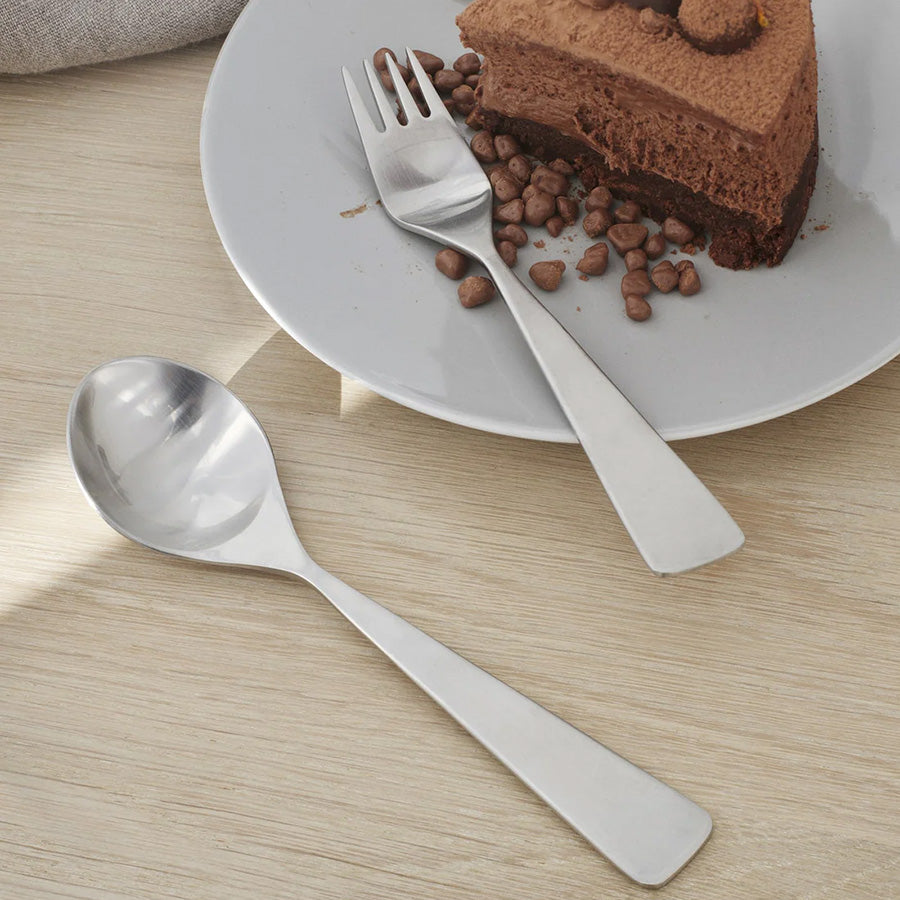 Maya dessertgaffel i rustfritt stål fra Stelton, sammen med en dessertskje, ideell for å nyte deilige kaker.