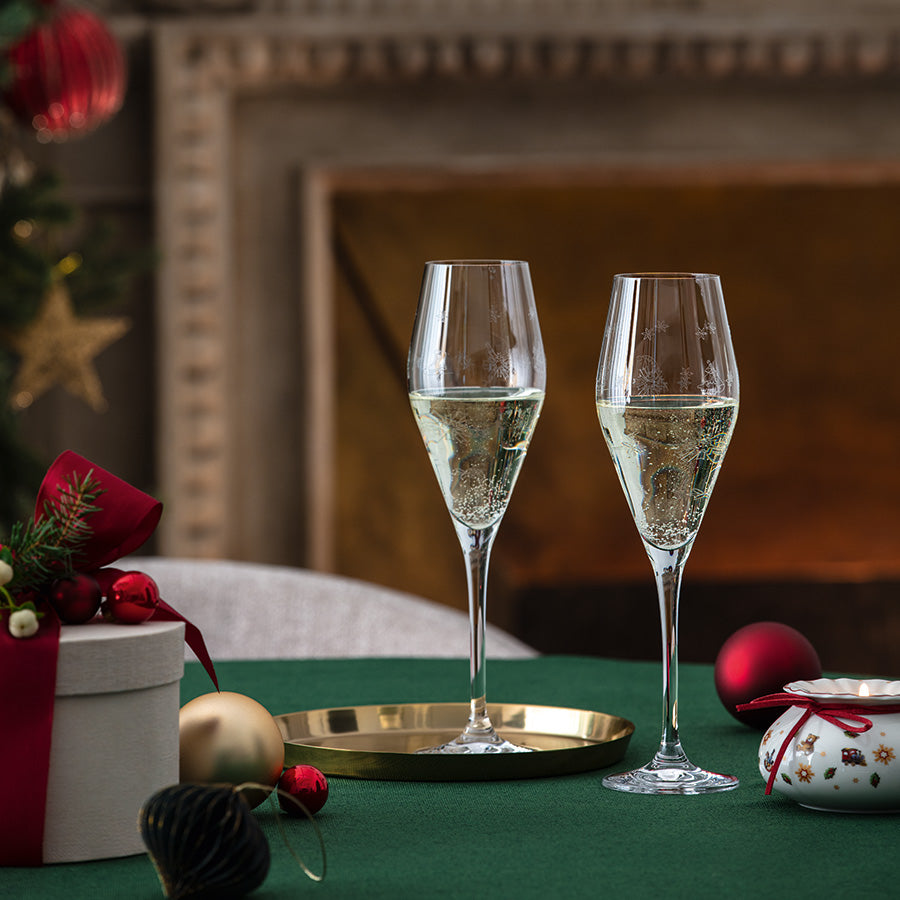 To Villeroy & Boch Toy's Delight champagneglass med musserende vin på festlig julebord foran peis