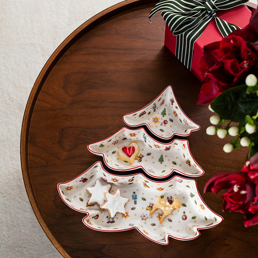 Tre Villeroy & Boch Toy's Delight juleskåler med julekaker på et festpyntet trebord
