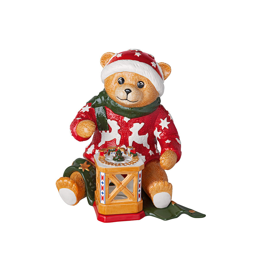 Villeroy & Boch Christmas Toy's Memory teddybjørn i rød julegenser og nisselue, sittende ved en dekorativ julelykt