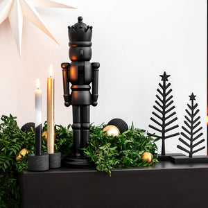 Sort Villeroy & Boch nøtteknekker dekorert i en elegant juleoppsats med lys, grønt og juletrepynt