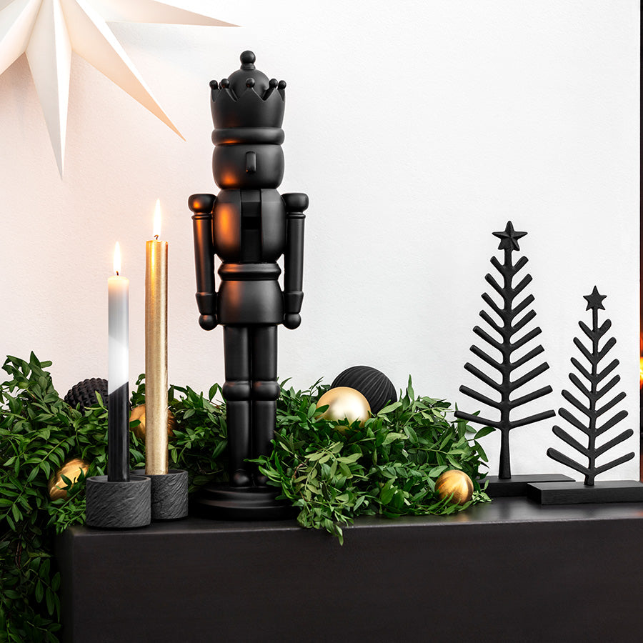 Sort Villeroy & Boch nøtteknekker dekorert i en elegant juleoppsats med lys, grønt og juletrepynt
