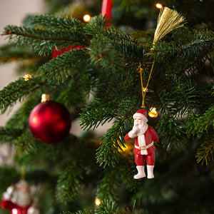 Julenisse-ornament fra Villeroy & Boch henger på et pyntet juletre med julelys og røde kuler
