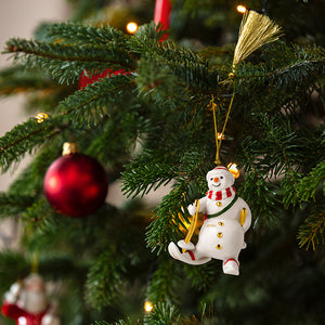 Villeroy & Boch snømann-ornament 2026 henger på et pyntet juletre med røde julekuler