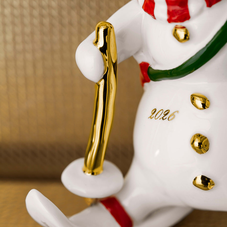 Nærbilde av Villeroy & Boch snømann-ornament med gullfarget stav, knapper og årstallet 2026