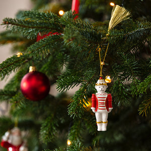 Nøtteknekker-ornament henger på et pyntet juletre med røde julekuler og lys