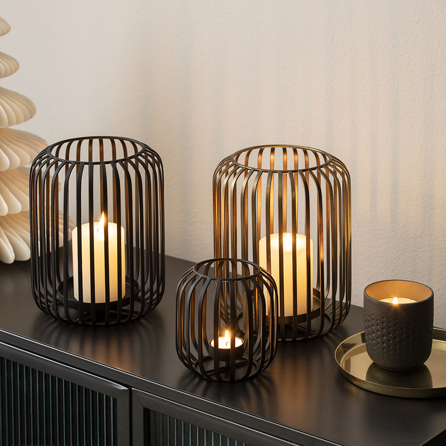 Sort Christmas Chic stormlykt med levende kubbelys, vist sammen med andre lykter