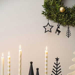 Christmas Chic julepynt fra Villeroy & Boch med svarte ornamenter på grønn julekrans over tente adventslys