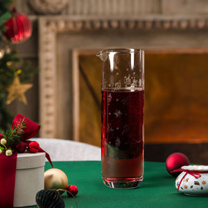 Villeroy & Boch Toy's Delight glassmugge fylt med rød juledrikk foran peisen