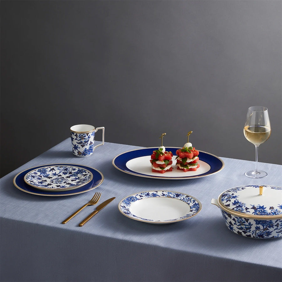 Elegant borddekking med Wedgwood Hibiscus Tallerken 20cm, sammen med matchende tallerkener og glass, ideell for spesielle anledninger.