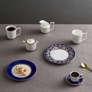 Samlet borddekorasjon med Wedgwood Renaissance Gold Fløtemugge 20cl, inkludert kopper og tallerkener i blått og gull.