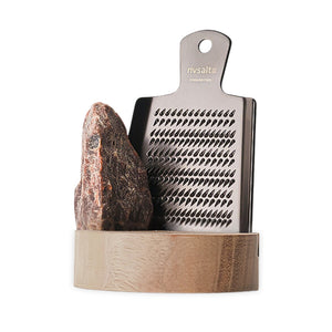 Adelante Rivsalt Kala Namak m/stativ Valnøtt + Rivjern, med en rustfritt stål rivjern og en stor saltstein i et elegant valnøttstativ, ideelt for aromatisk salting av mat.