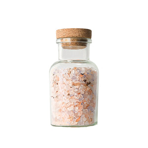 Adelante Rivsalt Rock Salt Blend i en glassflaske med kork, fylt med rosa steinsalt. Perfekt til både kjøkken og bord.