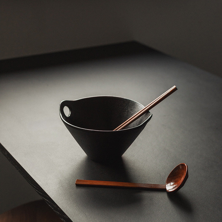 Moderne ramenbolle med skje og spisepinner på et bord, ideell for servering.