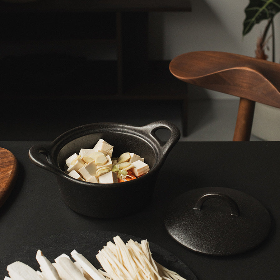 Ildfast form fylt med grønnsaker, med lokk ved siden, klar for tilberedning.