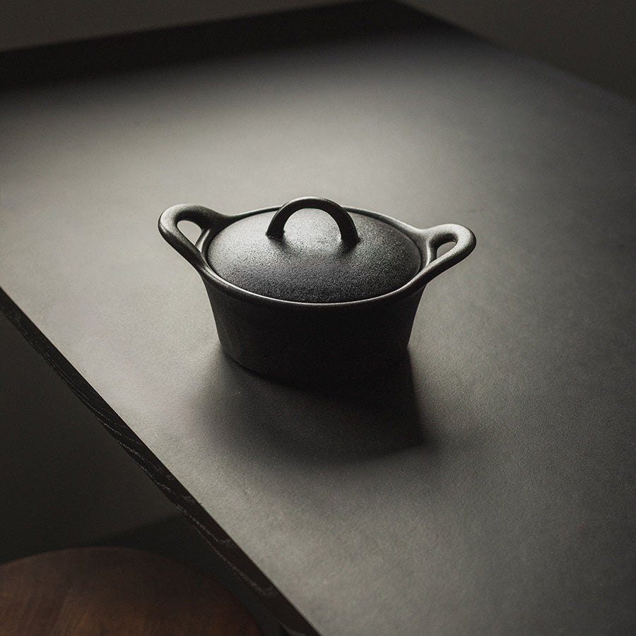 Elegant sort ildfast form på et bord, viser tidløst design og praktisk bruk.