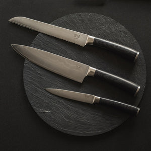 Antei Tokai knivsett med tre stilige kniver laget av damaskusstål, presentert på en svart steinplade, ideelt for kjøkkenbruk.